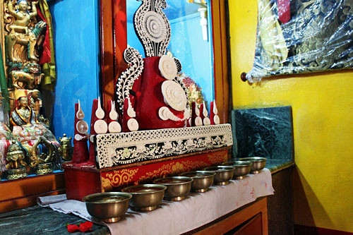 Pokhara-Shree-Gaden-Dhargay Ling Monastery3 Yak butter carving and seven bowls of water sit in front of Buddha on the altar